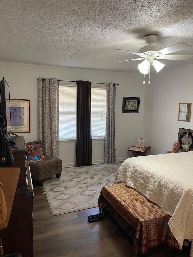 bedroom featuring a textured ceiling, wood-type flooring, and ceiling fan