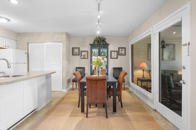 dining area with light tile patterned floors, track lighting, and baseboards