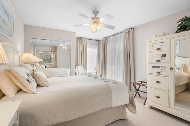 bedroom with a closet, light colored carpet, and a ceiling fan