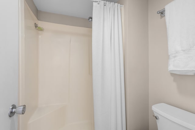 bathroom featuring toilet and a shower with curtain