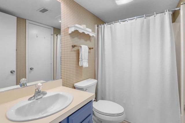 bathroom featuring vanity, a shower with shower curtain, toilet, and visible vents