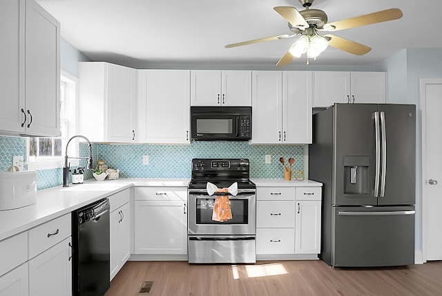 kitchen featuring black appliances, a sink, light countertops, and white cabinetry