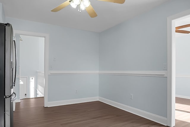 empty room featuring dark wood finished floors, baseboards, and ceiling fan