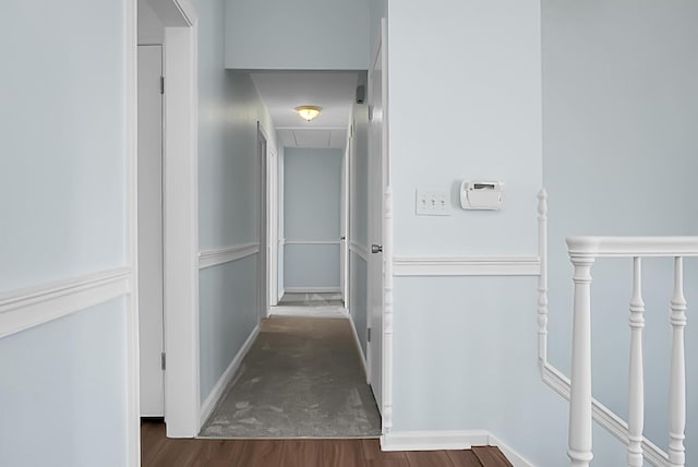 corridor with attic access, baseboards, and wood finished floors