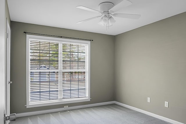 empty room featuring visible vents, baseboards, a ceiling fan, and light colored carpet