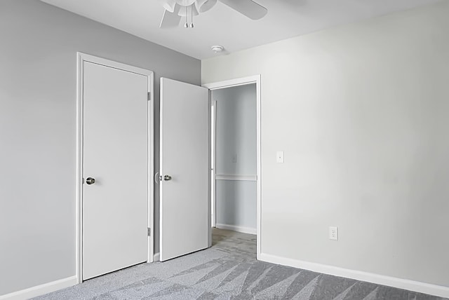 unfurnished bedroom featuring a ceiling fan, baseboards, and carpet flooring