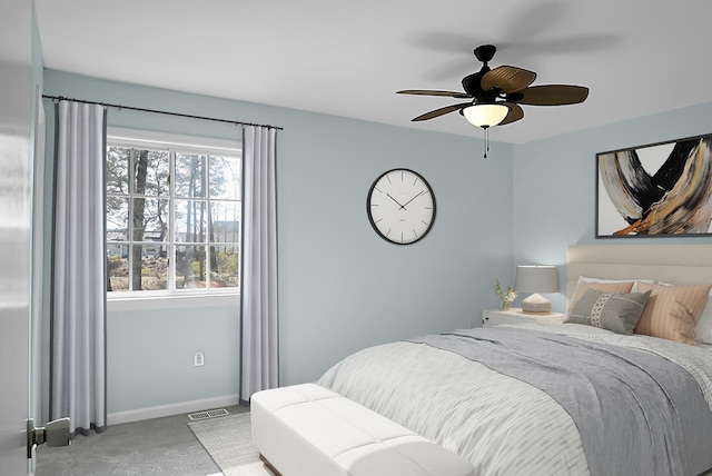 carpeted bedroom featuring visible vents, baseboards, and ceiling fan