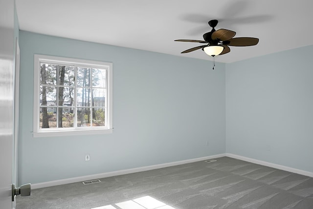 unfurnished room with a ceiling fan, carpet flooring, visible vents, and baseboards