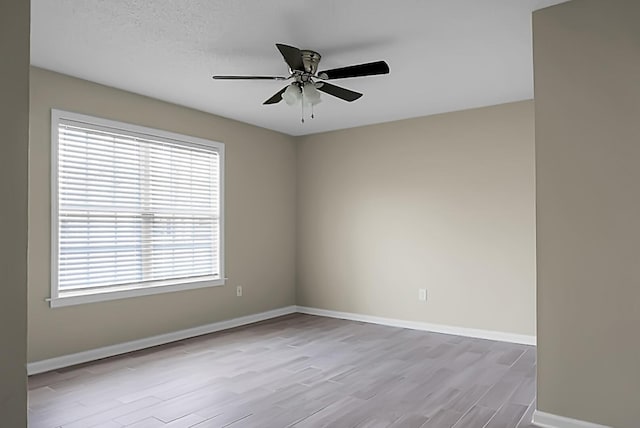 unfurnished room featuring ceiling fan, wood finished floors, and baseboards