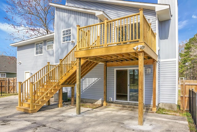 rear view of property featuring a deck, central AC, fence, stairs, and a patio area