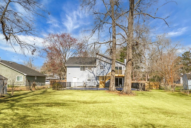 back of house with fence, stairway, and a lawn