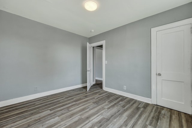 unfurnished bedroom featuring baseboards and wood finished floors