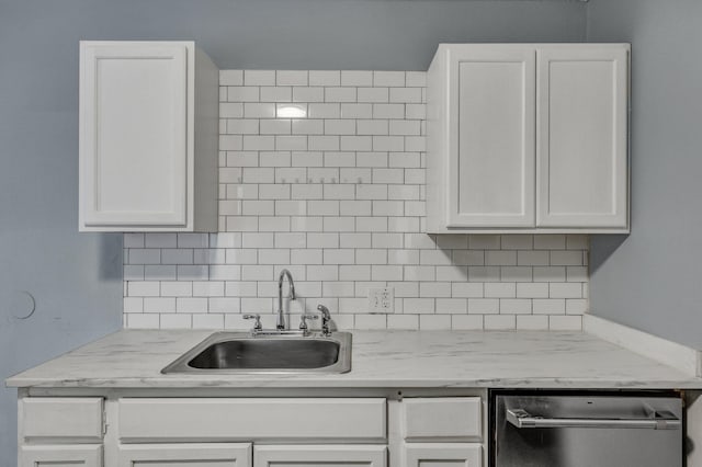 kitchen featuring white cabinetry, a sink, and backsplash