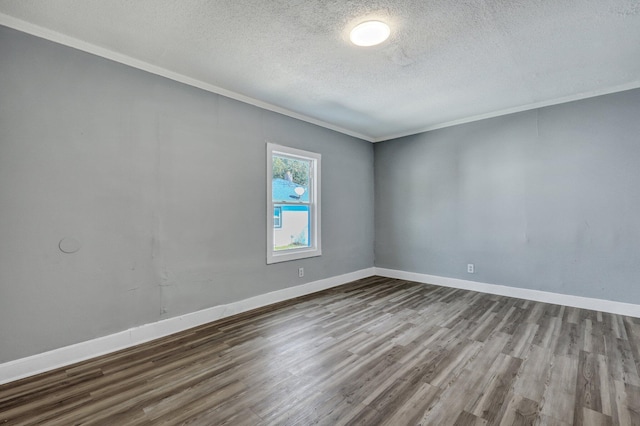 spare room featuring baseboards, a textured ceiling, wood finished floors, and crown molding