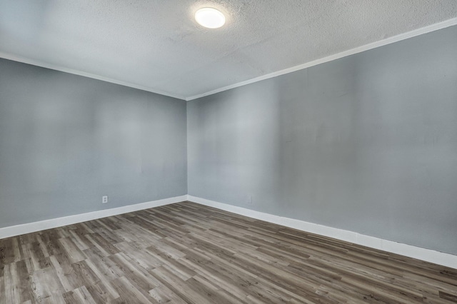 empty room featuring ornamental molding, a textured ceiling, baseboards, and wood finished floors