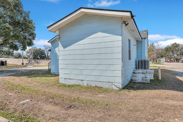 view of side of property with crawl space and central AC