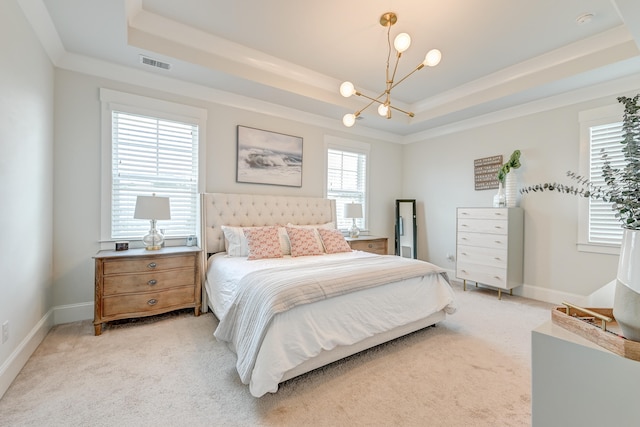 bedroom with an inviting chandelier, light colored carpet, and a tray ceiling