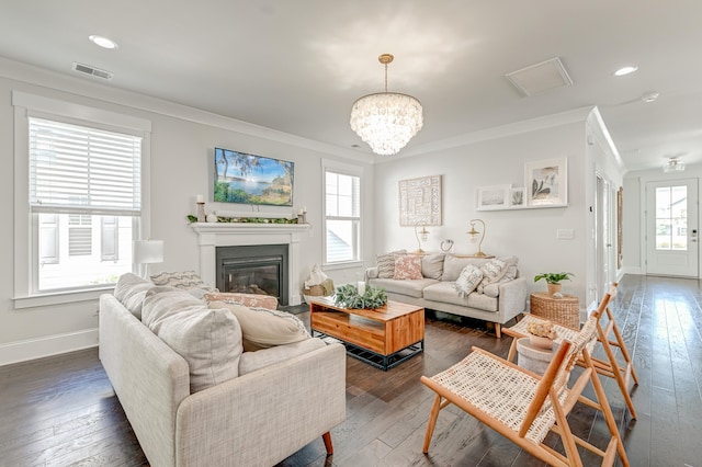 living room with plenty of natural light, dark hardwood / wood-style flooring, and crown molding