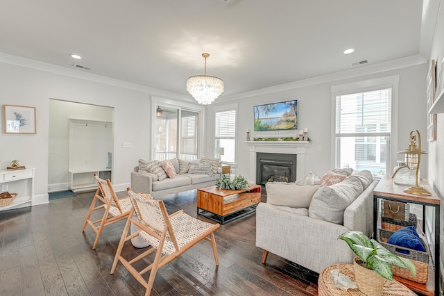 living room with crown molding, an inviting chandelier, and dark hardwood / wood-style flooring