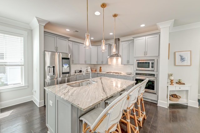 kitchen featuring tasteful backsplash, appliances with stainless steel finishes, wall chimney range hood, and a healthy amount of sunlight