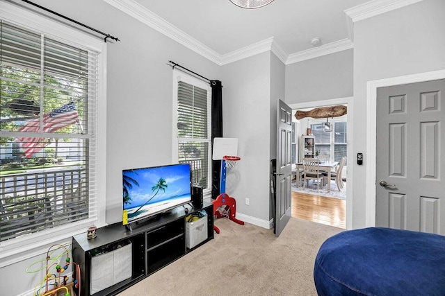 sitting room with light carpet, a healthy amount of sunlight, and crown molding