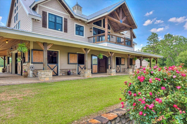 rear view of property with covered porch and a yard