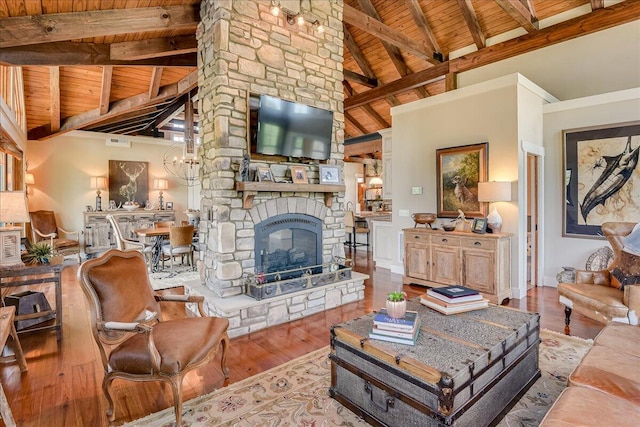 living room featuring wood ceiling, beamed ceiling, light hardwood / wood-style floors, high vaulted ceiling, and a stone fireplace