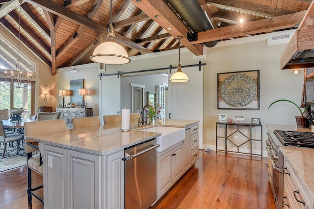 kitchen featuring decorative light fixtures, beamed ceiling, a breakfast bar, appliances with stainless steel finishes, and wood ceiling