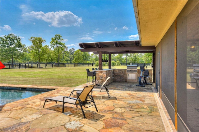 view of terrace featuring an outdoor kitchen and a fenced in pool