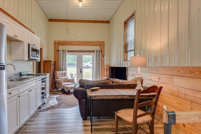 living room featuring light hardwood / wood-style floors, french doors, and sink