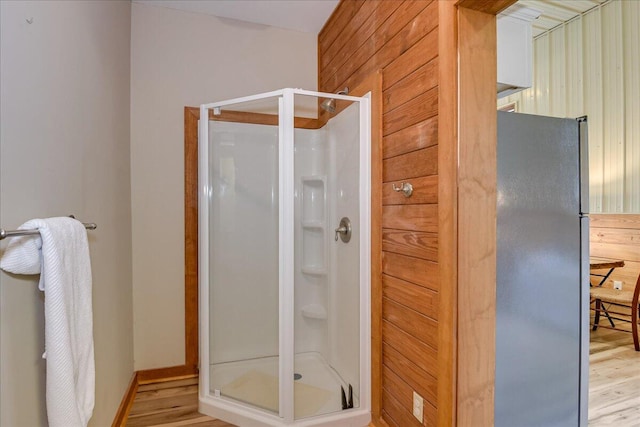 bathroom with a shower with door and hardwood / wood-style flooring