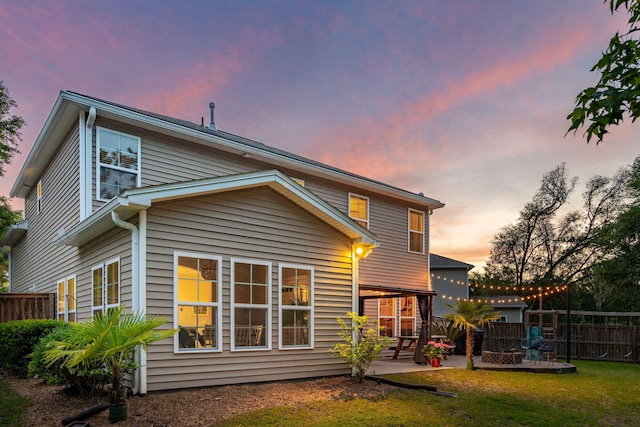 1606 Stovall Ct, Johns Island, SC 29455 - back of property at dusk with a yard, a patio area, and fence