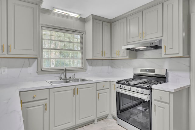 kitchen featuring light stone counters, sink, and gas stove