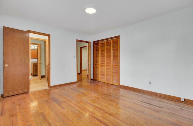 unfurnished bedroom featuring light hardwood / wood-style flooring and a closet