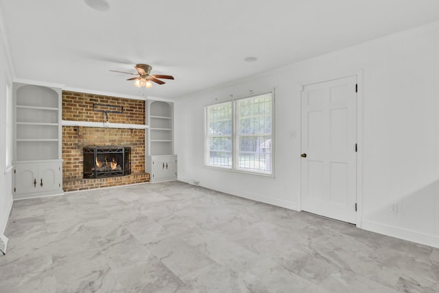 unfurnished living room with ceiling fan, a brick fireplace, built in features, and ornamental molding