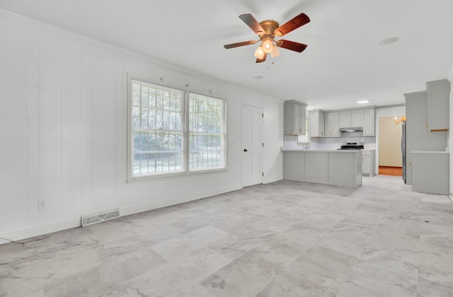 unfurnished living room with ceiling fan and crown molding