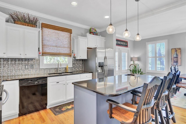 kitchen with light wood finished floors, black dishwasher, a sink, stainless steel fridge with ice dispenser, and a breakfast bar area