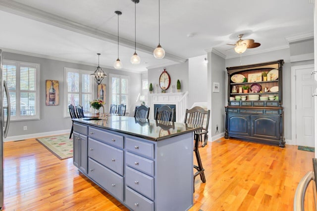 kitchen featuring dark countertops, light wood-style flooring, a center island, and gray cabinetry