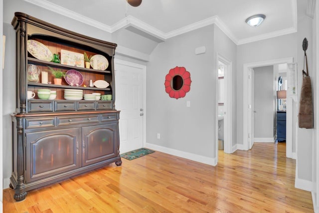 interior space with baseboards, ornamental molding, and light wood-style flooring