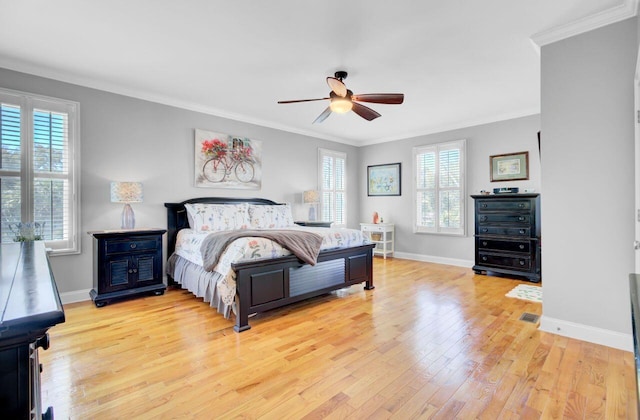 bedroom with baseboards, ornamental molding, light wood-style floors, and a ceiling fan