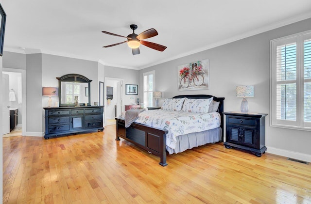 bedroom with multiple windows, light wood-type flooring, and baseboards