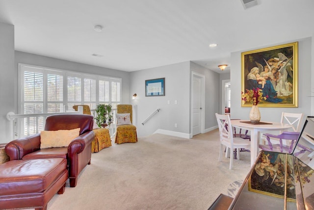living room with baseboards, visible vents, and light carpet
