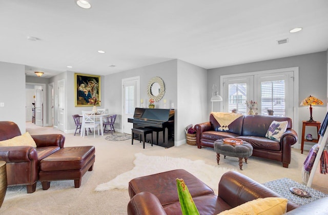 living area featuring light colored carpet, visible vents, baseboards, and recessed lighting