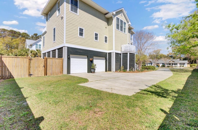 view of property exterior with fence, a lawn, driveway, and an attached garage