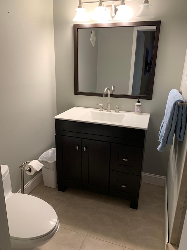 bathroom featuring tile patterned flooring, toilet, and vanity