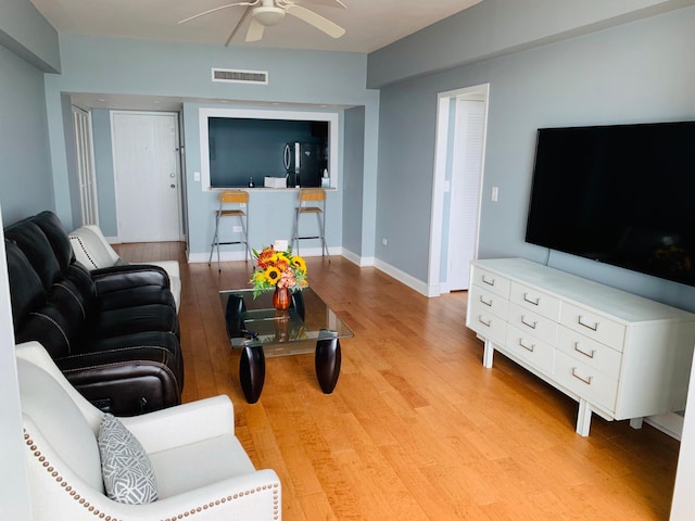 living room with light hardwood / wood-style flooring and ceiling fan