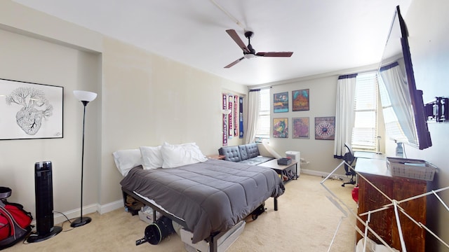 bedroom featuring ceiling fan, light carpet, and multiple windows