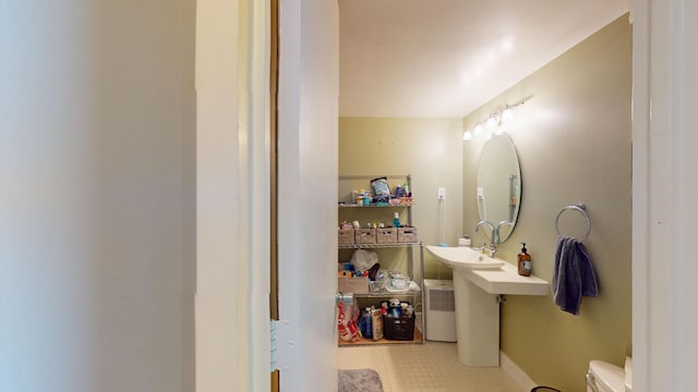 bathroom featuring tile patterned flooring, toilet, and sink