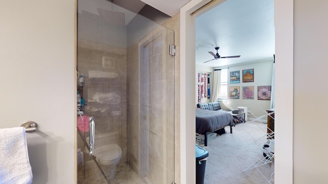 bathroom with a shower with shower door, ceiling fan, and toilet