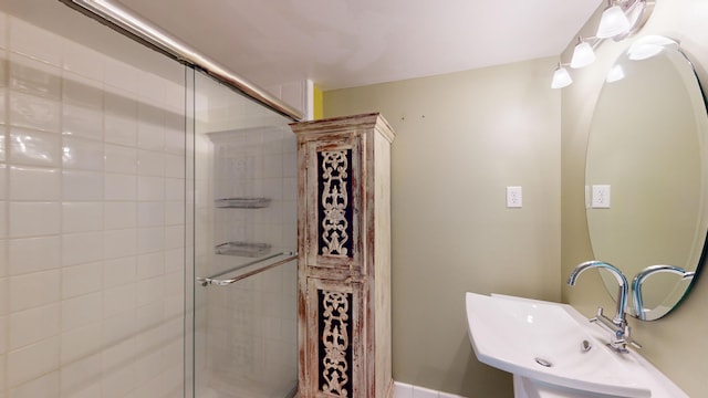 bathroom featuring an enclosed shower and sink